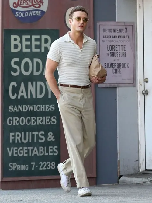 This may contain: a man is walking down the street in khaki pants and a polo shirt