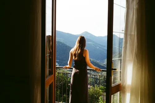 Back View of a Woman Standing on the Balcony · Free Stock Photo