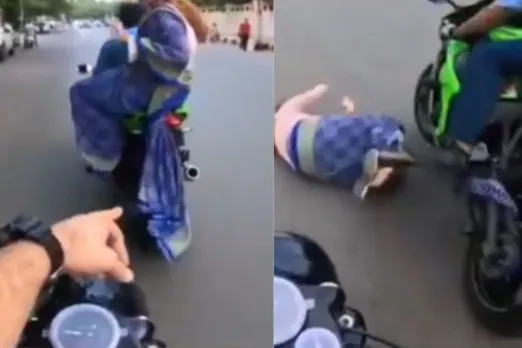 A woman pillion rider falls down from motorcycle