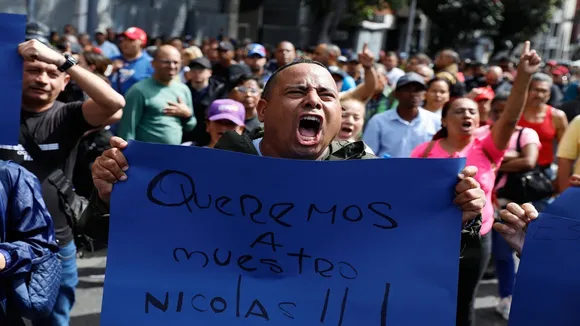 A supporter of Venezuelan President NicolÃ¡s Maduro displays a sign reading in Spanish "We want our NicolÃ¡s" during a rally in Caracas, Venezuela, Saturday, Jan. 3, 2026, after U.S. President Donald Trump announced Maduro had been captured and flown out of the country.