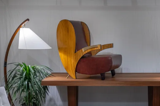 A satin wood art deco lounge chair with brass handles, upholstered in oxblood leather