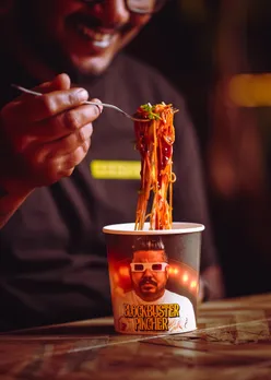 A picture of a person eating a cup of spicy noodles