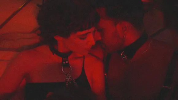 couple wearing  collars sharing an  intimate moment in  red lighting,  symbolising India’s  underground kink  subcultures and  BDSM community