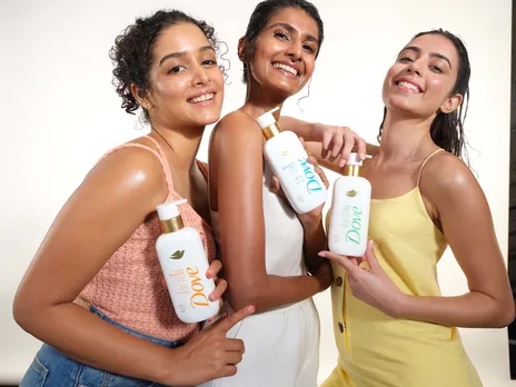 Three Indian women holding dove's body washes in their hand as part of their body care routine