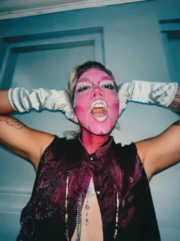 A person decked up in make-up and gloves to show transmasculine identity, along with face jewellery, poses for the camera to show the impact of redefining masculinity
