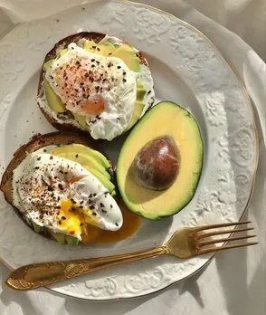 A breakfast plate with foods for strong nervous system such as eggs and avocados on toast.