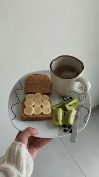 A plate with toast, fruit, nut butters and kiwi, all foods that improve memory and concentration