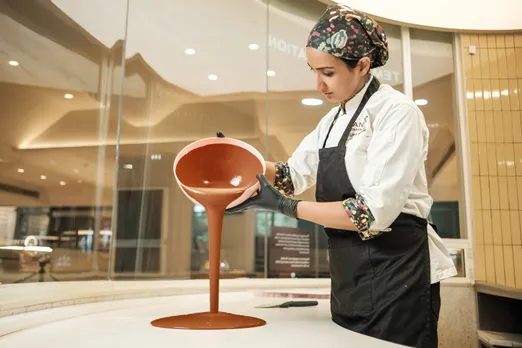 Ruby Islam, the head chef at Manam Chocolate, pours molten chocolate as she tempers it to show how chocolate is made from Indian cacao to give Indian bean-to-bar chocolate