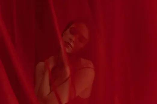 A woman behind a red cloth dealing with the signs of victim mentality