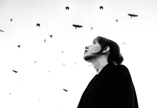 A woman looking at the sky and feeling helpless due to her victim mentality psychology