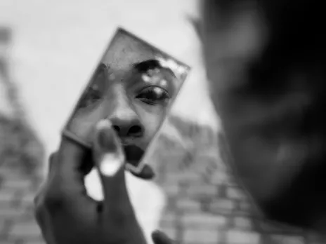 A person with victim mentality seeing themselves in a small mirror