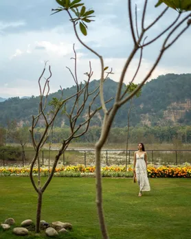A woman walks around on the grounds of a resort nestled at the foothills to show heritage boutique hotels India which have plenty to do within their premises, making them the best boutique hotels monsoon India.