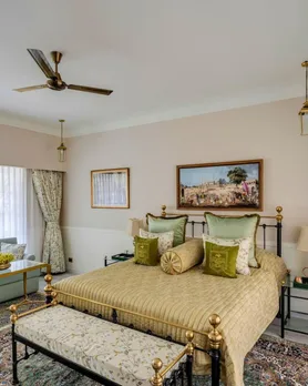 A picture of a cosy but tastefully done room with a double bed, cushions and decor that reeks of luxury, to show how boutique resorts India are embracing heritage to be best boutique hotels monsoon India.