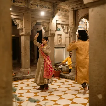 A picture of a man and a woman dancing in the courtyard of a heritage fort to show how dance performances can make the best boutique hotels monsoon India as the offer the amenities of luxury boutique hotels in India and  give visitors something to do.
