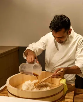 A man pours soy on top of rice to show how Japanese restaurants in India are trying to serve the most authentic version of Japanese cuisine in India possible.