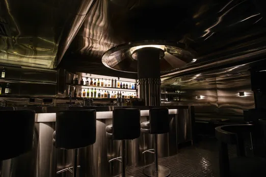 A dark bar with minimal lighting and bar seats to depict the rise of Izakaya bar in India as well as Japanese spirits India