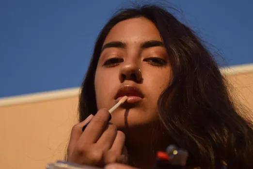 A woman applying a lip gloss containing the Dirty dozen list of endocrine disruptors