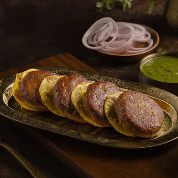 A zoomed in picture of a tandoor, where kebabs are getting cooked on coals and flames to show how one of the most Indian snacks, the kebab, has become the core street food Lucknow