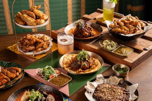 A picture of a spread of dishes--pakora towers, maa ki dal, kebabs, chhole and rotis to depict Punjabi dishes that form the core of Punjabi food history and Punjabi home cooking