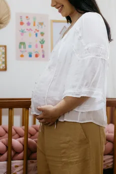 A pregnant woman touching her belly, in need of emotional support during pregnancy