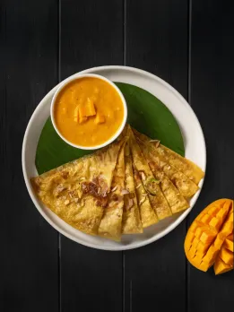 A picture of a plate of yellow chila/dosa/Indian pancake with a bowl of curry to show how the best vegetarian fine dining India are serving vegetarian tasting menus India