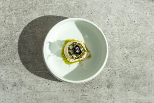 A picture of a layered vegetarian dish served in a white, round plate, to show how vegetarian fine dining India has gone to the next level and top fine dining vegetarian restaurants India are dishing out reaching a wider audience with their tasting menus