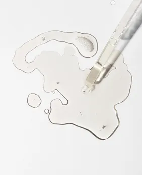 A flatlay shot of serum and a pipette on a white surface