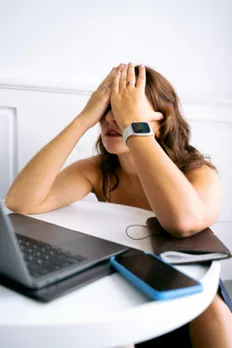 A woman sitting on her work desk stressed and worried due to PMS