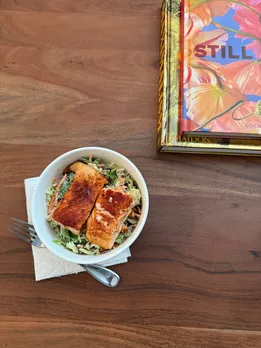 A picture of a bowl of food lying on a wooden table