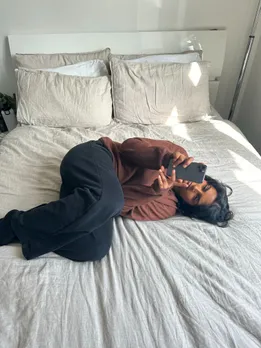 A person curls up in bed to show the negative impact of ghosting in relationships or slow fade breakup