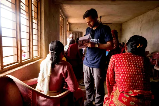 A man in a rural area of India assisting the local residents there