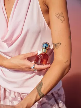 Cacharel Parfums vanilla perfume bottle in a woman's arm