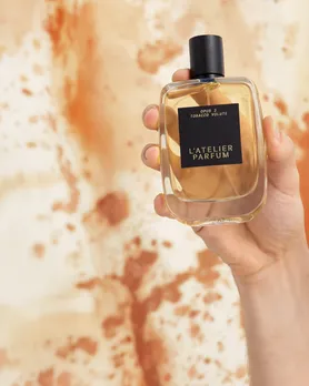 L'Atelier Parfum Tobacco Volute perfume bottle held in a human's shoot