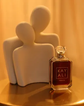 Kayali Vanilla 28 perfume placed against a marble showpiece