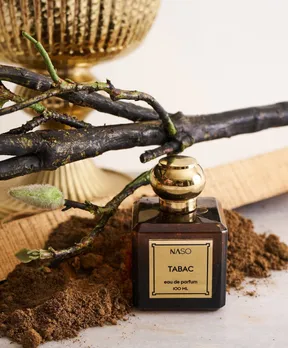 NASO Tabac vanilla perfume on a table with forest-themed elements