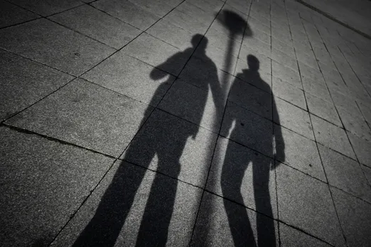 A black and white silhouette of the shadows of two men on a pavement to show how same-sex couples adoption India is a possibility, leading to a rise in queer parenting in India and inclusivity and queer families despite hurdles