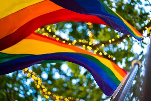 A picture of multiple rainbow colored flags as a representation of queer parenting in India and the rise of LGBTQ+ families in India despite difficult surrogacy laws for queer couples India