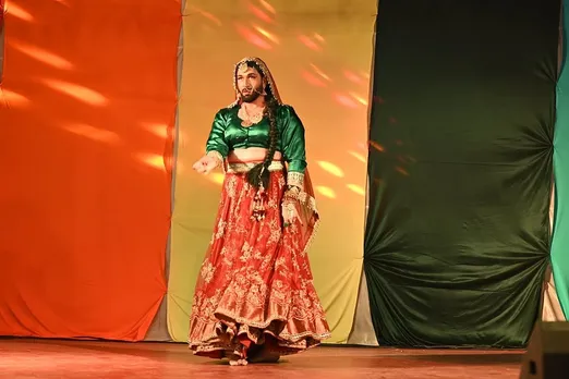 A picture of  a person wearing a green and red Indian ethnic outfit to depict raising kids in queer families and queer parenting in India
