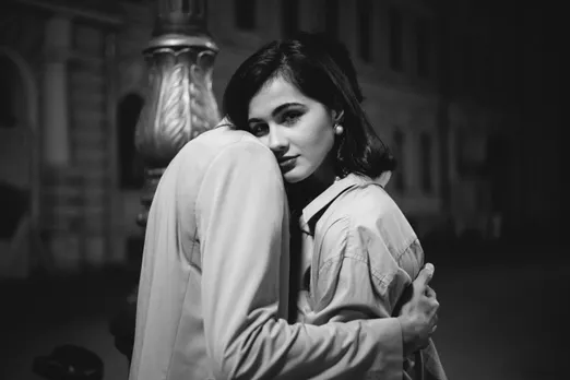 A black and white picture of a woman begrudgingly hugging her date to show how digital body language doesn't always translate to real life meetings, especially when people don't even make the effort to put thought into how to plan a first date, changing the idea of first impressions in dating.