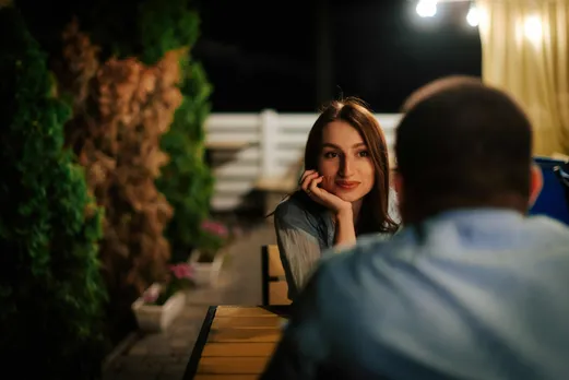 A picture of a woman looking at a man to depict how first impressions in dating are formed when people meet in person, which makes it easier to spot things like first date red flags and the thought gone into how to plan a first date