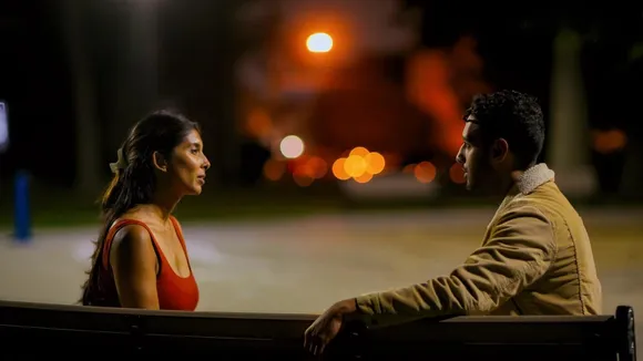 A picture of a woman sitting on a bench on a footpath with a man to show how first impressions in dating have evolved to pave the way for decoding digital body language before following any first date tips 2025 in real life