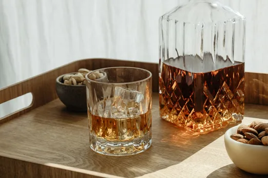 A picture of a decanter and a glass kept next to it to show how single malt whisky is most popularly consumed as people accept and learn how to drink single malt in a way that helps consumers enjoy the best single malt whisky in the world