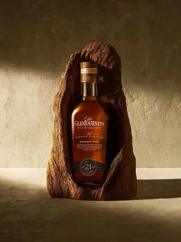 A picture of a bottle of GlenJourney single malt whisky in a wooden cask to depict the growing popularity of single malt whisky including some of the best single malt whisky from the world as people are no confused about single malt vs blended whisky as well as growing interest in how single malt whisky is made