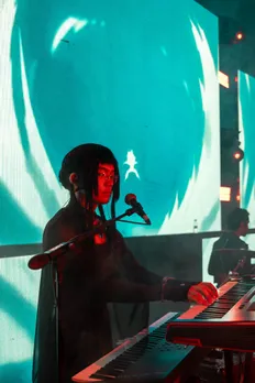 A picture of a musician playing the keyboard while wearing an anime cosplay outfit to showcase how Asian influence in India has spread via anime
