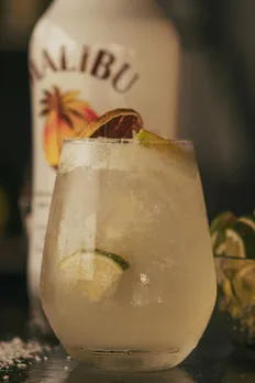 A picture of a white cocktail made with a bottle of white rum in the background to show how rum for cocktails India work as well as how India has gone beyond imported rum India even when it comes to rum gifting India