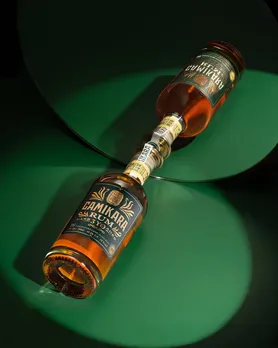 A picture of a bottle of Camikara against a mirror, to show how to choose the best rum in India and where to buy premium rum in India, besides how the best rum in India is today at par with imported rum India.