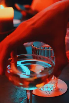 A picture of a hand holding a cocktail glass to show how premium rum brands India are being used as rum for cocktails India.