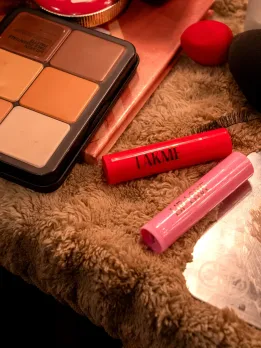 A picture of two lip balms from Lakmē placed on a vanity table