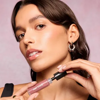 A picture of a model with a lip product in her hand