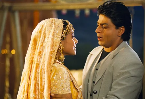 A still from Kuch Kuch Hota Hai, where a woman is standing in her bridal attire and crying in front of a man wearing a suit to show how cushioning in dating is due to the friends to lovers Bollywood trope.